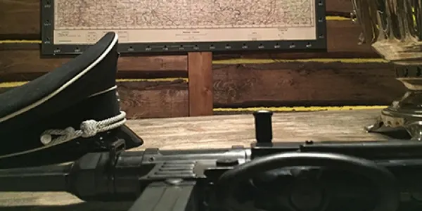Casquette d'officier et fusil sur une table de cartes